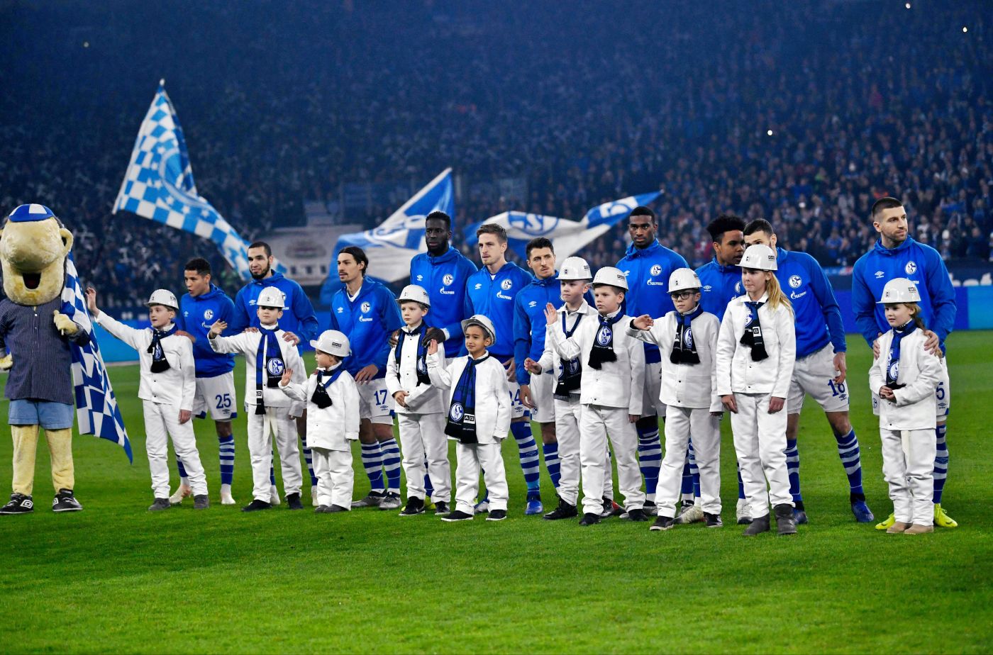 -- Schalke's players stand behind player escorts wering miner's clothes ahead of the German first division football match between FC Schalke 04 and Bayer Leverkusen on December 19, 2018. When Germany's last black coal mine shutters on December 21, 2018, it's not just workers who may shed a tear -- football fans too will mourn the end of the over 150-year-old industry. The industrial Ruhr region -- rich in coal, the blood and soul of industrial Germany since the 19th century -- is also the gritty home turf of some of Germany's best-loved football clubs. - Germany OUT / DFL REGULATIONS PROHIBIT ANY USE OF PHOTOGRAPHS AS IMAGE SEQUENCES AND/OR QUASI-VIDEO
 / AFP / dpa / Ina Fassbender / DFL REGULATIONS PROHIBIT ANY USE OF PHOTOGRAPHS AS IMAGE SEQUENCES AND/OR QUASI-VIDEO