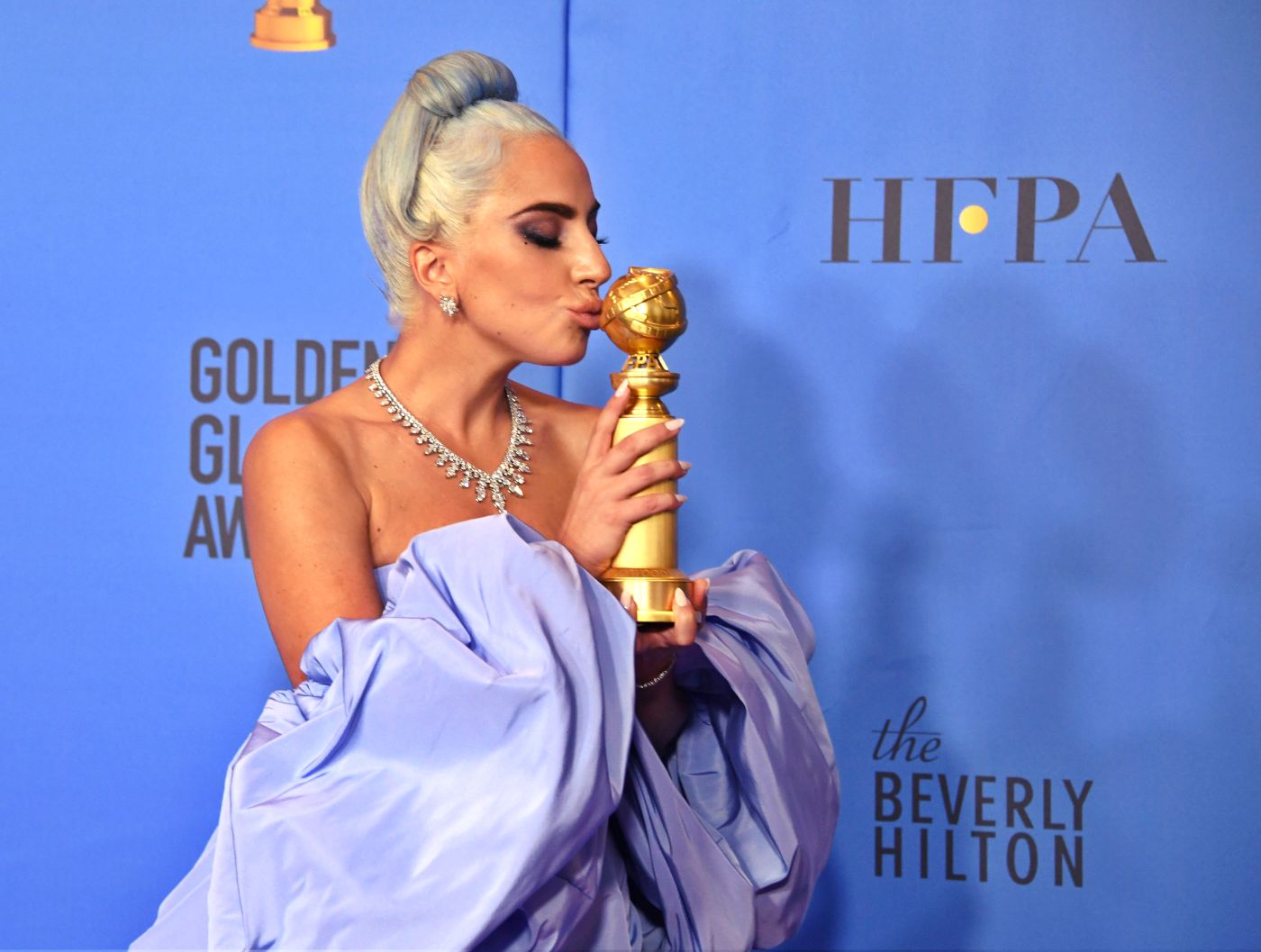 Lady Gaga posa junto a su premio por mejor canción original en “A Star ir Born”.