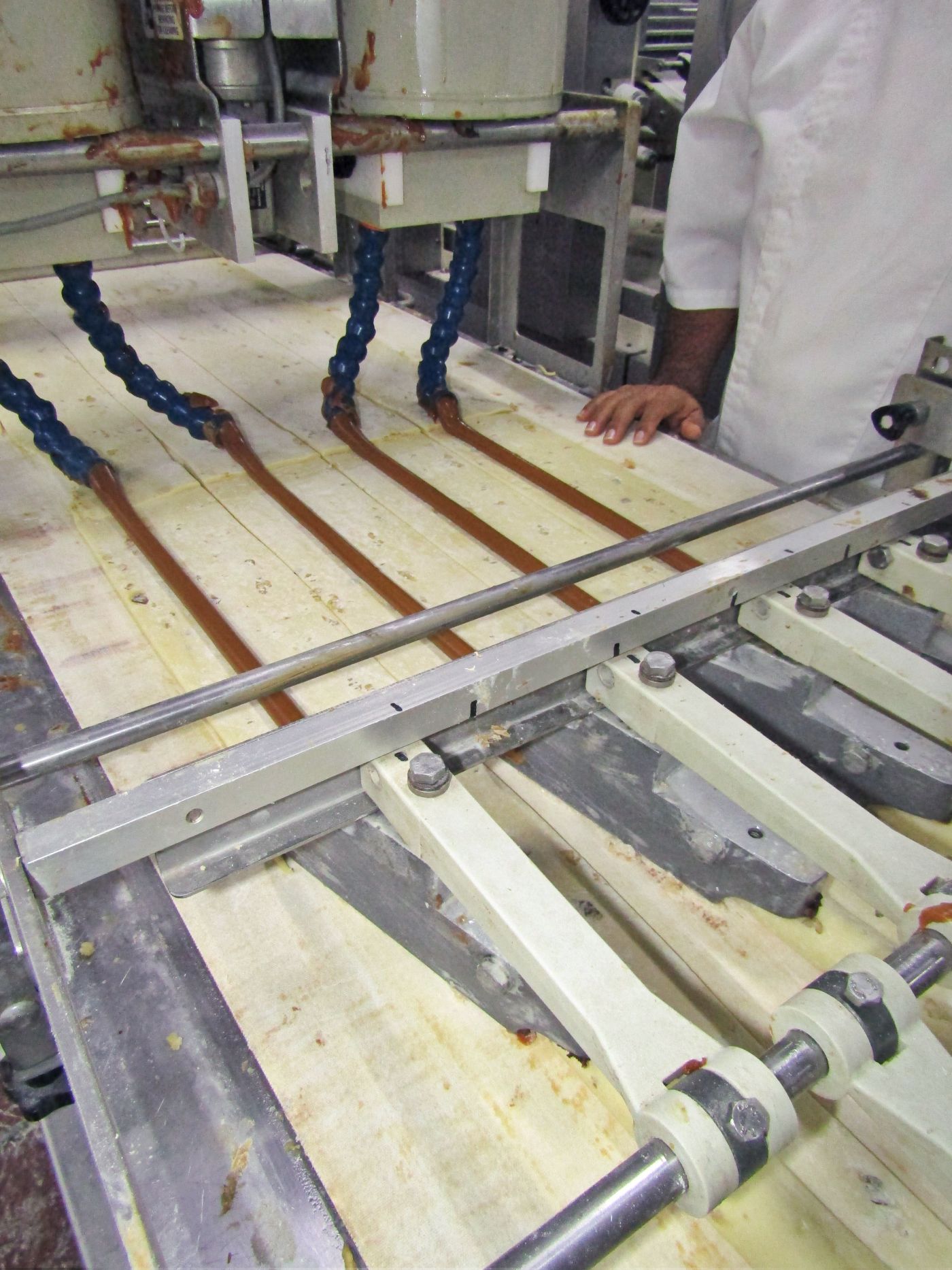 1. Una máquina se encarga de rellenar de manjar o chocolate la masa para cuatro roscas simultáneamente.